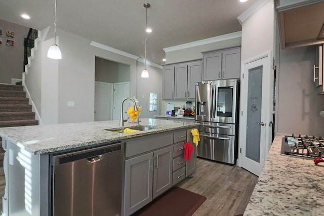 kitchen with a sink, appliances with stainless steel finishes, a kitchen island with sink, and gray cabinetry