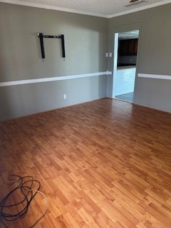 unfurnished room featuring wood-type flooring and crown molding