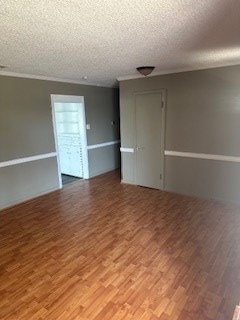 spare room featuring wood-type flooring and a textured ceiling