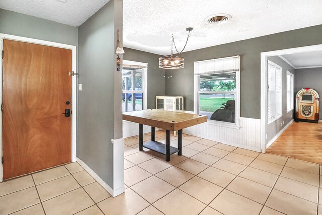 foyer with a textured ceiling and light hardwood / wood-style flooring