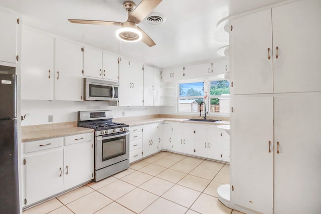 kitchen featuring light tile patterned flooring, sink, white cabinetry, and stainless steel appliances