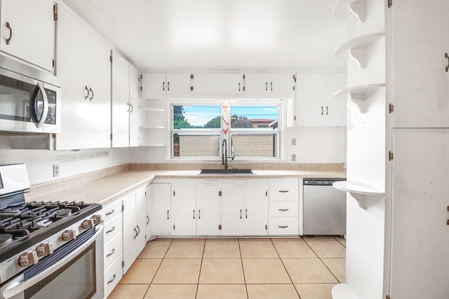 kitchen featuring light tile patterned flooring, sink, white cabinetry, and stainless steel appliances