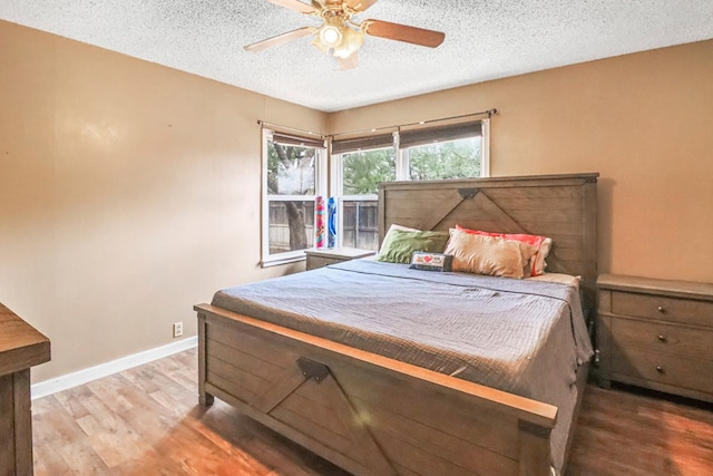 bedroom featuring hardwood / wood-style flooring, ceiling fan, and a textured ceiling