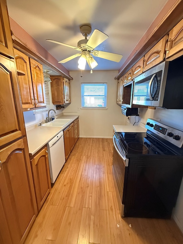 kitchen with ceiling fan, electric range, sink, white dishwasher, and light wood-type flooring