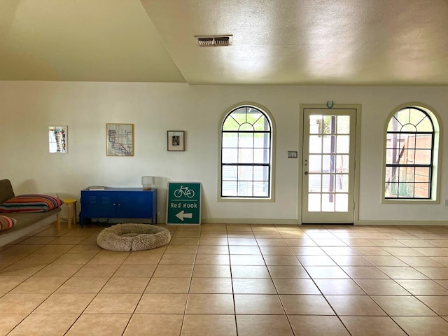 entryway featuring light tile patterned flooring and a textured ceiling