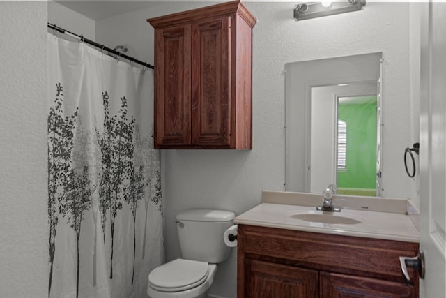 bathroom with a shower with curtain, vanity, and toilet