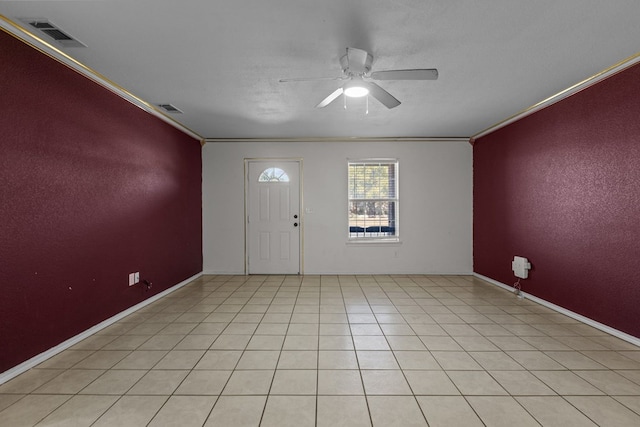 tiled entryway with ceiling fan, ornamental molding, and a textured ceiling