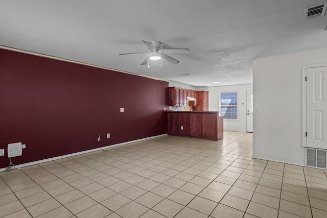 unfurnished living room featuring light tile patterned flooring, a textured ceiling, and ceiling fan