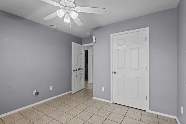 unfurnished bedroom with light tile patterned floors and ceiling fan