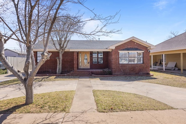 view of front of home featuring brick siding and roof with shingles