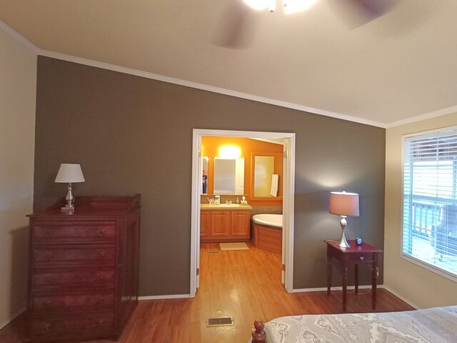 bedroom featuring ensuite bath, ceiling fan, light hardwood / wood-style flooring, and crown molding