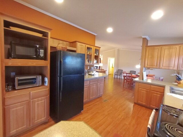 kitchen featuring sink, ornamental molding, black appliances, and light hardwood / wood-style floors