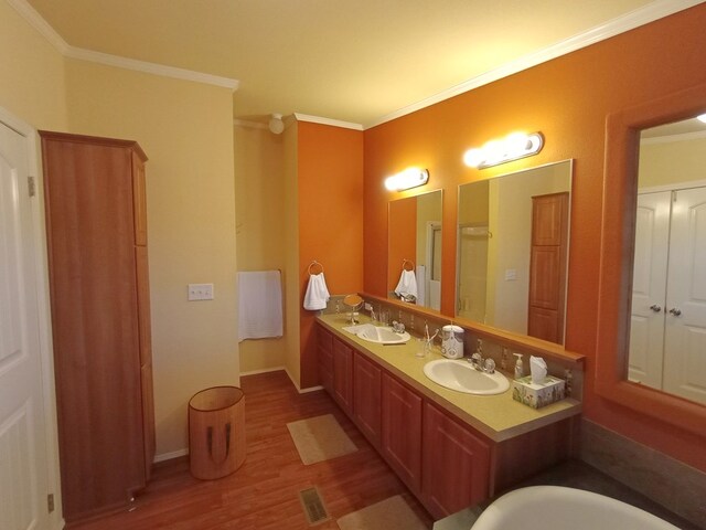 bathroom with independent shower and bath, crown molding, vanity, and wood-type flooring