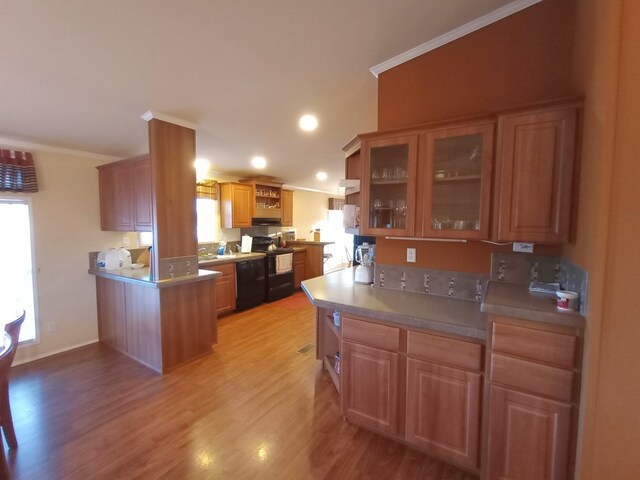 kitchen featuring ornamental molding, black appliances, and light wood-type flooring