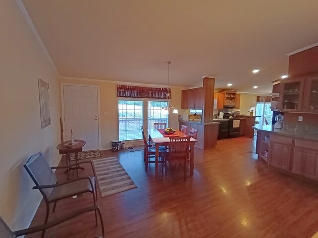 dining space with dark hardwood / wood-style floors and crown molding