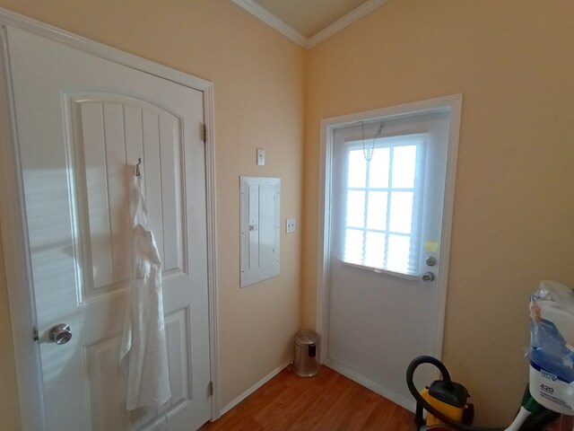 doorway to outside with light hardwood / wood-style floors, crown molding, and electric panel