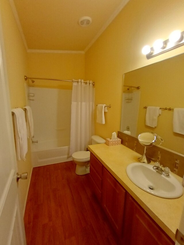 full bathroom featuring shower / bath combination with curtain, vanity, crown molding, hardwood / wood-style floors, and toilet