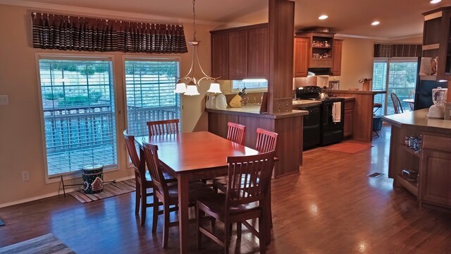 dining space with a notable chandelier, ornamental molding, and dark wood-type flooring