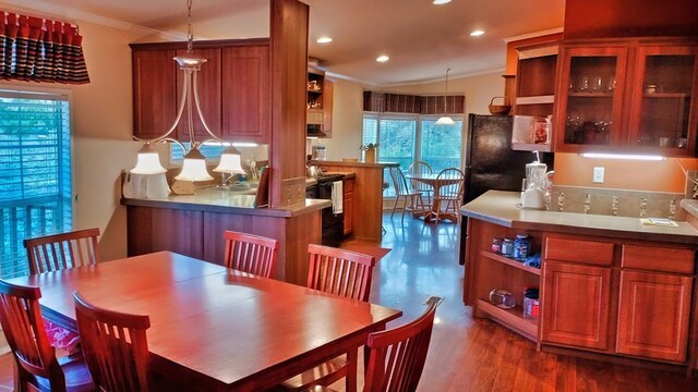 dining area with dark hardwood / wood-style floors, ornamental molding, and an inviting chandelier