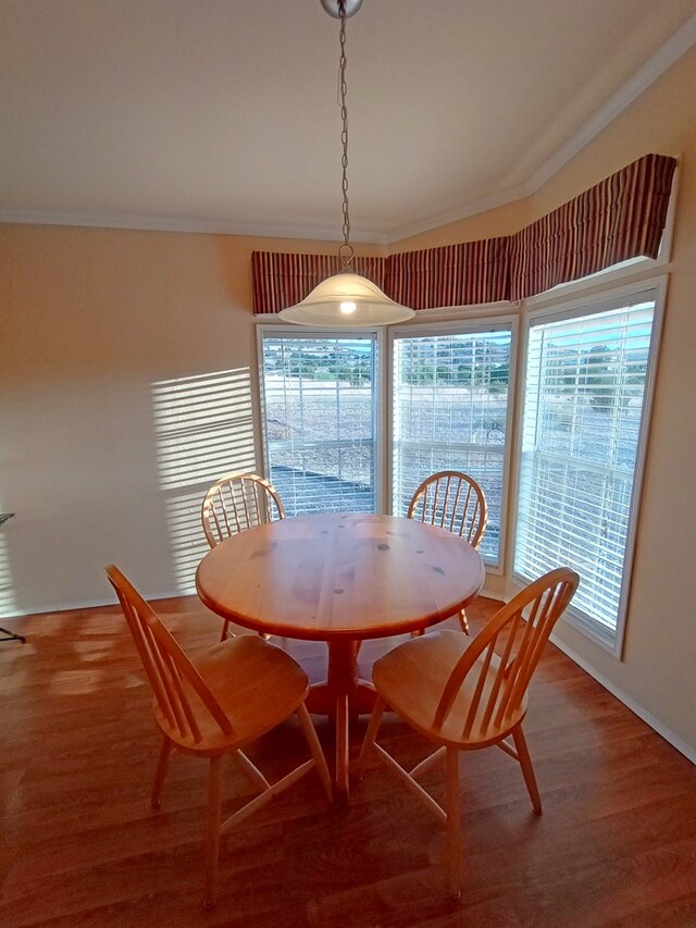 dining area with wood-type flooring and ornamental molding