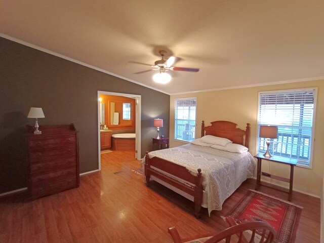 bedroom with hardwood / wood-style flooring, ceiling fan, connected bathroom, and multiple windows