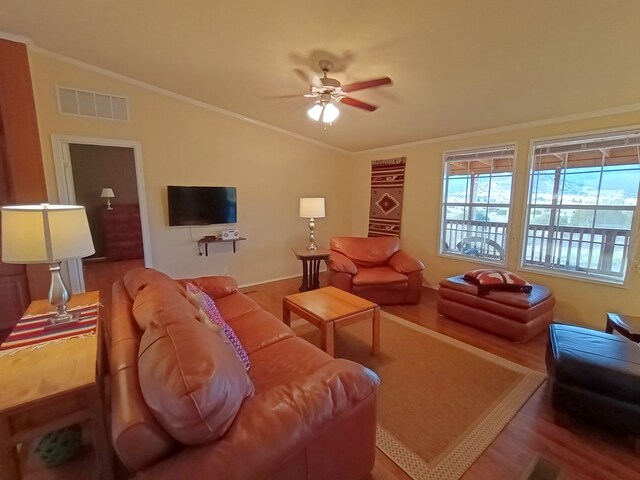 living room with hardwood / wood-style floors, ceiling fan, lofted ceiling, and crown molding