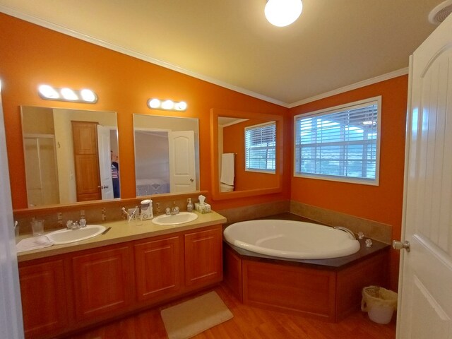 bathroom with ornamental molding, vanity, vaulted ceiling, separate shower and tub, and hardwood / wood-style flooring