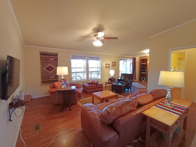 living room featuring hardwood / wood-style floors, ceiling fan, and ornamental molding