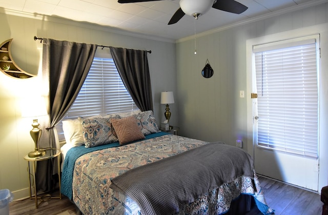 bedroom featuring dark hardwood / wood-style flooring, ceiling fan, and ornamental molding