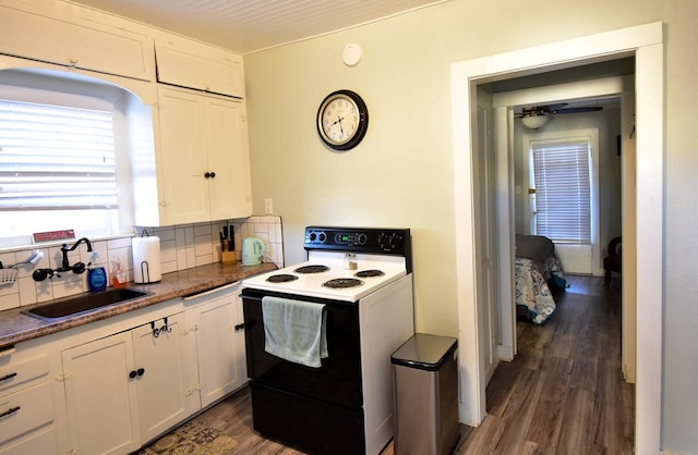 kitchen featuring decorative backsplash, white cabinets, and white electric stove