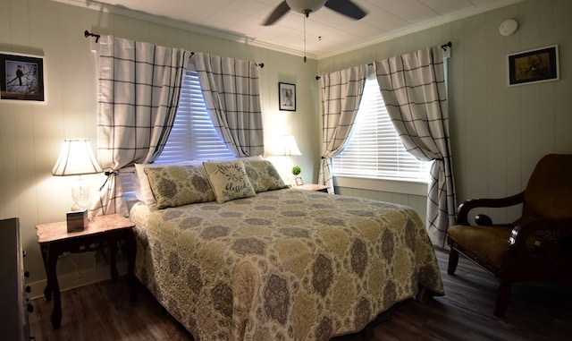 bedroom with dark hardwood / wood-style floors, ceiling fan, and ornamental molding