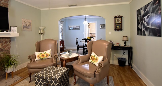 living area with hardwood / wood-style flooring and ornamental molding