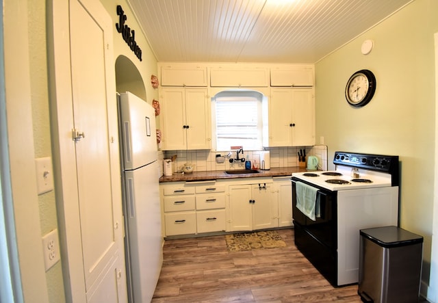 kitchen with sink, backsplash, light hardwood / wood-style floors, white appliances, and white cabinets