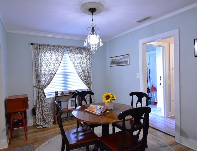 dining room featuring light hardwood / wood-style floors and ornamental molding