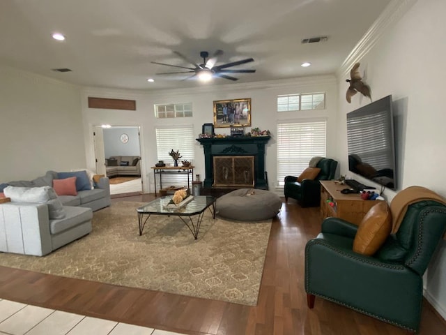 living room featuring hardwood / wood-style flooring, ceiling fan, and crown molding