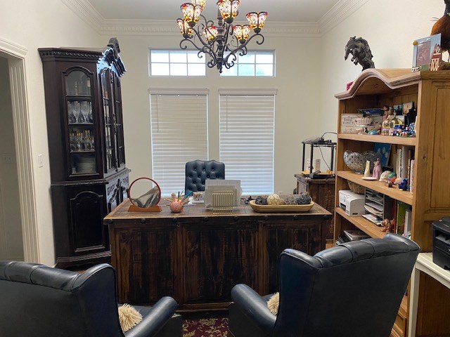 office space with ornamental molding and an inviting chandelier