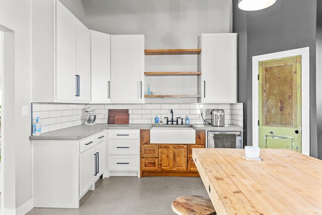 kitchen featuring decorative backsplash, white cabinetry, and sink