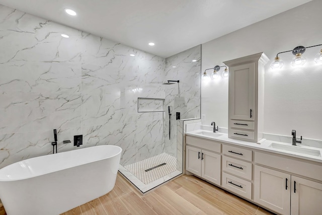 full bathroom with a soaking tub, double vanity, a marble finish shower, and a sink