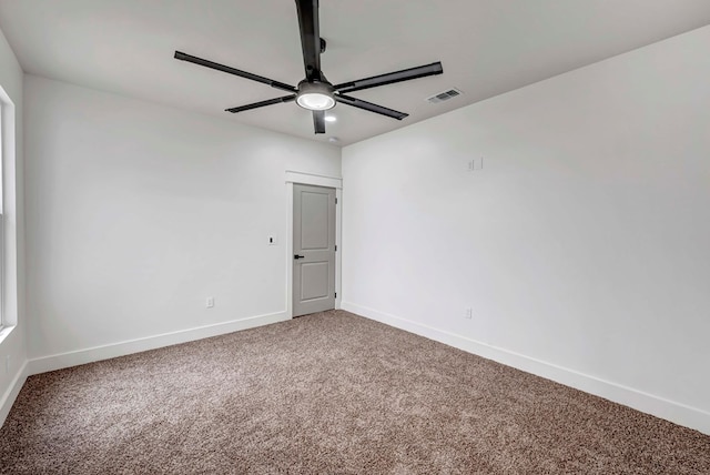 carpeted empty room featuring visible vents, ceiling fan, and baseboards