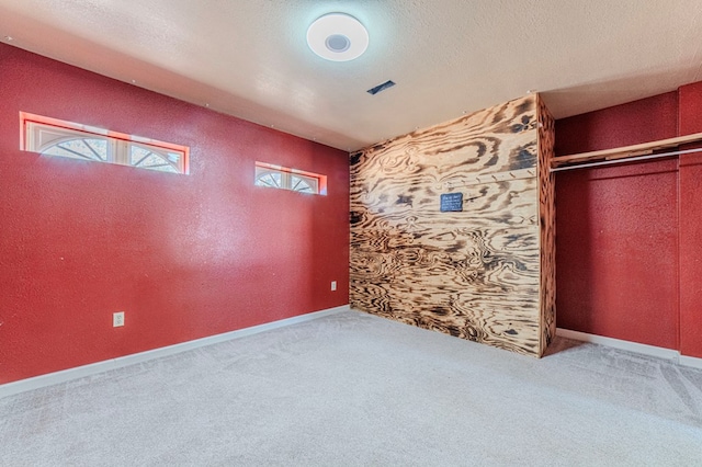 unfurnished bedroom with a textured ceiling, a closet, and carpet