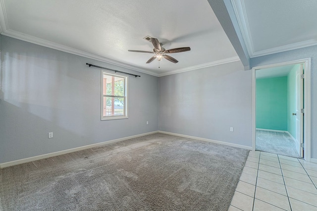 spare room featuring light carpet, ceiling fan, and crown molding