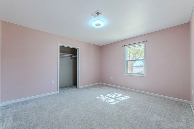 unfurnished bedroom featuring a closet and light carpet