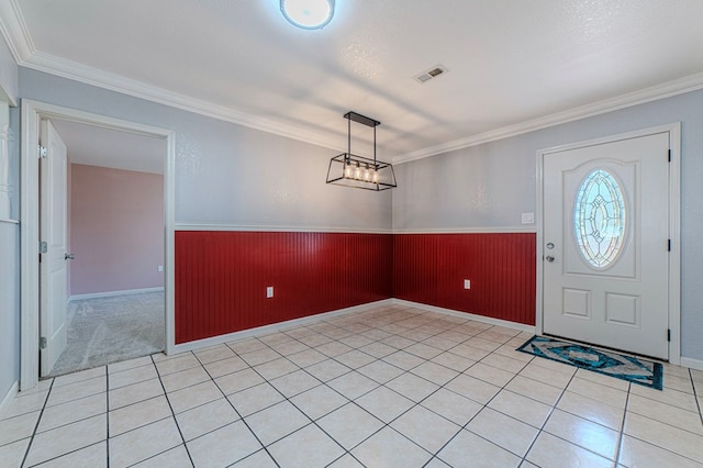 tiled foyer entrance with a textured ceiling and crown molding