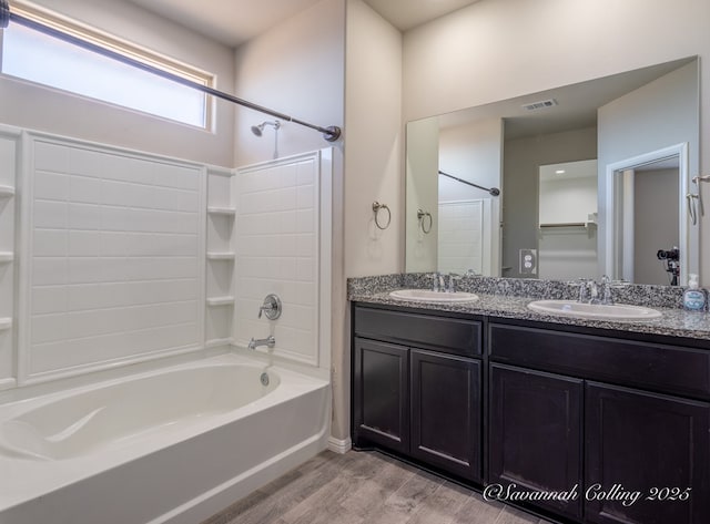 bathroom with vanity, hardwood / wood-style flooring, and washtub / shower combination