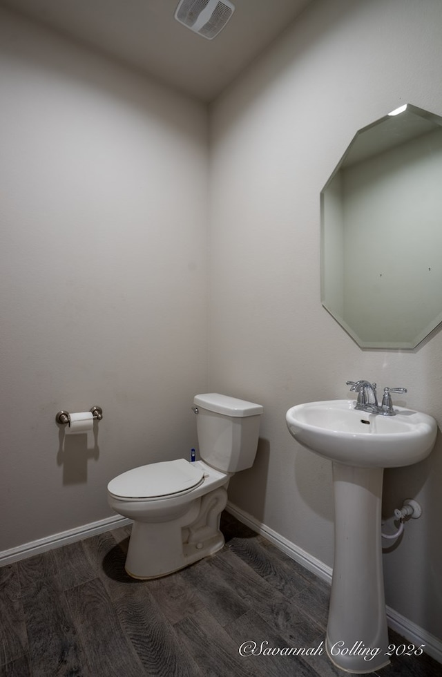 bathroom with hardwood / wood-style floors, sink, and toilet