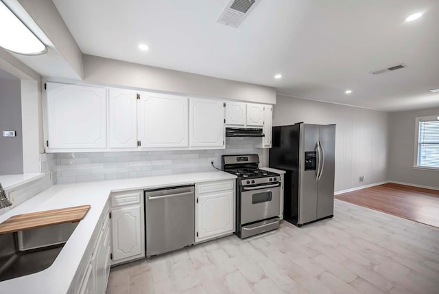 kitchen featuring stainless steel appliances, light countertops, visible vents, and white cabinets