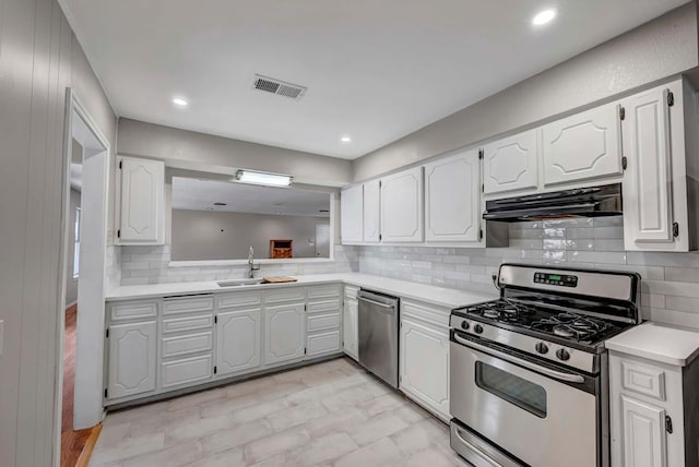 kitchen with white cabinets, under cabinet range hood, stainless steel appliances, and light countertops