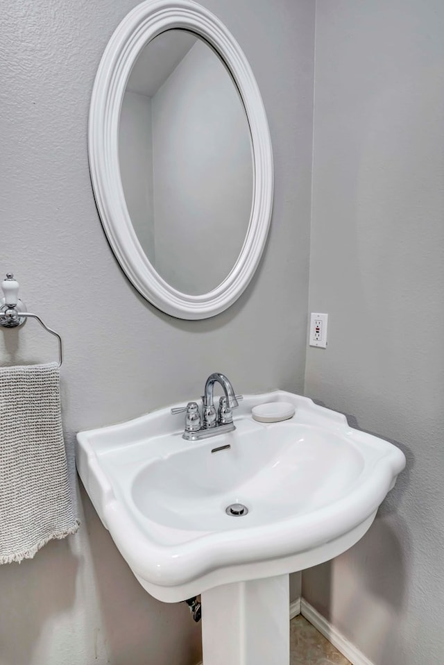 bathroom with a sink and baseboards