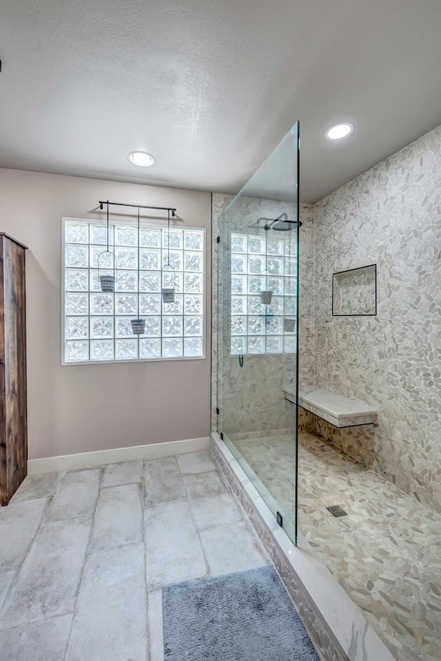 bathroom with a walk in shower, a textured ceiling, recessed lighting, and baseboards