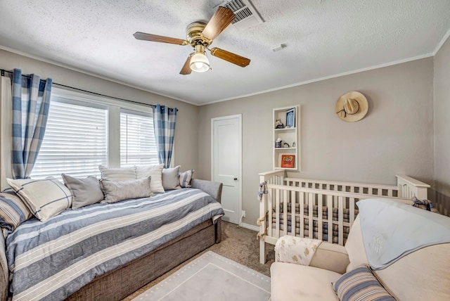 bedroom with visible vents, light colored carpet, ceiling fan, crown molding, and a textured ceiling